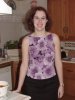 Nicely dressed Jill stands in her kitchen