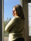 Suzanne stands by the window